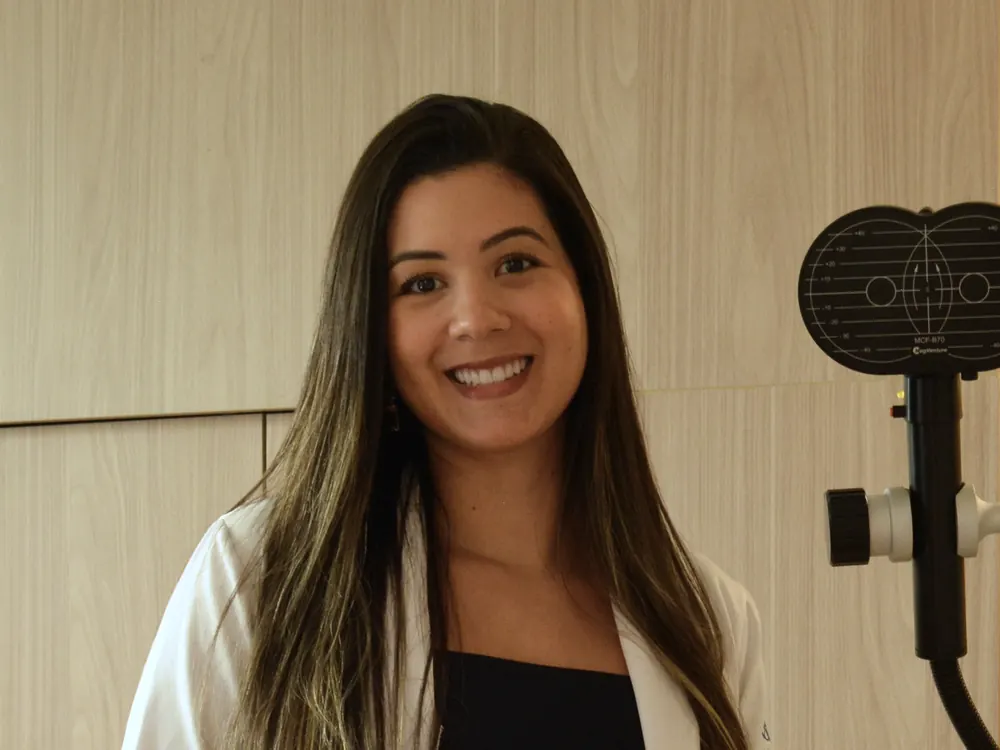 Retrato da Dra. Luana Amorim na Florence Salvador, ao lado da bobina de estimulação do equipamento de neuromodulação