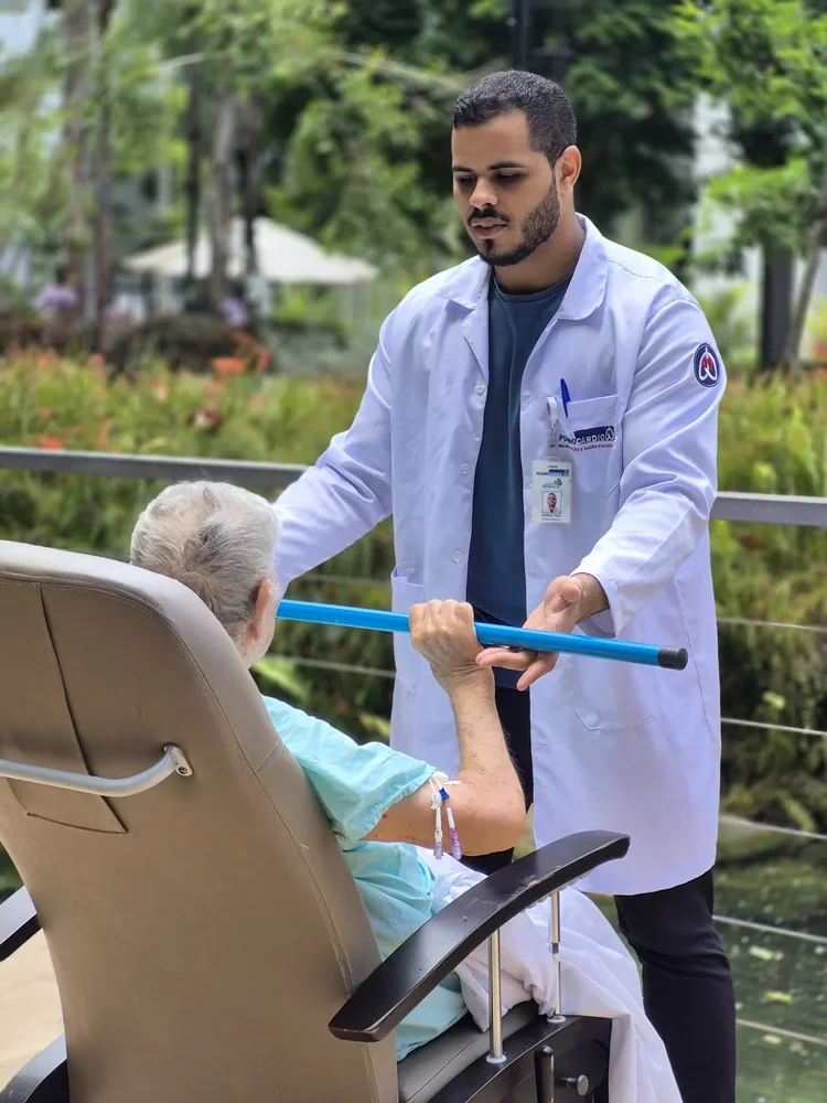 Profissional de reabilitação acompanhando paciente em terapia motora.